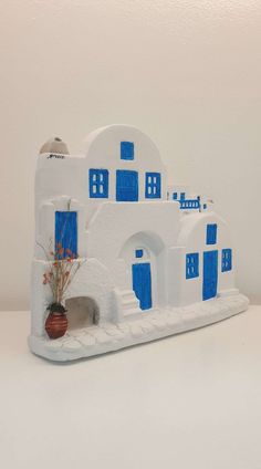 a small white and blue building on a table