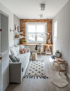 a living room filled with furniture and a white rug on top of a hard wood floor