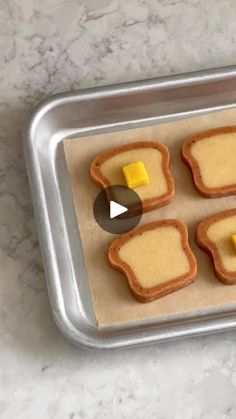 four pieces of bread with cheese on them sitting in a baking pan, ready to be baked