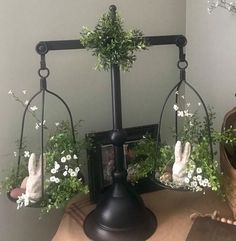 an old fashioned scale with flowers and plants in it on a table next to a potted plant