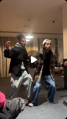 two men are dancing in the middle of a room