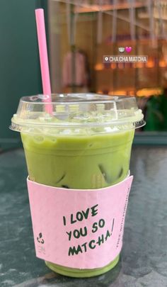 a green smoothie in a plastic cup with a pink straw and i love you so matcha sticker