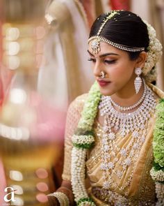 a woman in a bridal outfit sitting next to a vase