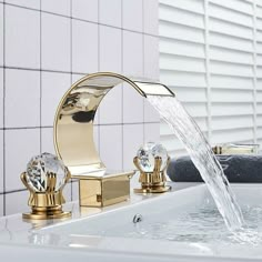 a faucet with water running from it's sides in a white tiled bathroom