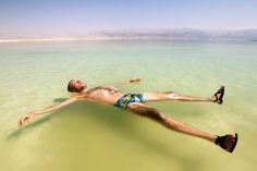 a man is floating in the water on his stomach and legs with one foot up