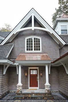 a gray house with white trim and red door