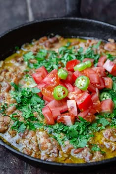 a skillet filled with lots of food on top of a wooden table