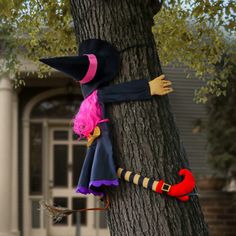 a scarecrow is hanging on the side of a tree