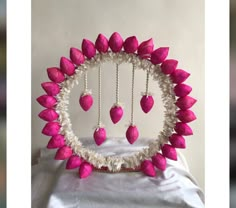 a pink and white decoration with hearts hanging from it's centerpiece, on top of a white table cloth