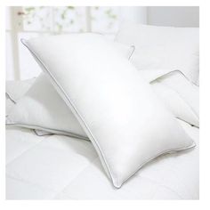 two white pillows sitting on top of a bed next to each other in front of a window