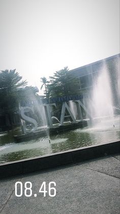 a large sign that is on the side of a building with water shooting out of it