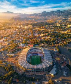 an aerial view of the sun setting over a soccer stadium