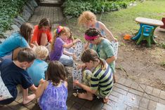 a group of children sitting around each other on the ground playing with blocks and balloons