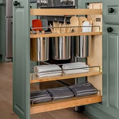 an open cabinet in a kitchen with pots and pans on the bottom shelf,