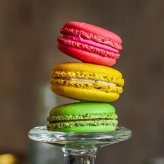 a stack of colorful macaroons sitting on top of a glass plate