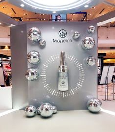 a display with silver balls and a bottle on it