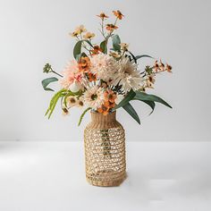 a vase filled with lots of flowers on top of a table