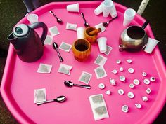 a pink table topped with lots of different types of utensils and other items