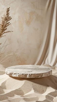 a white plate sitting on top of a table next to a plant in a vase