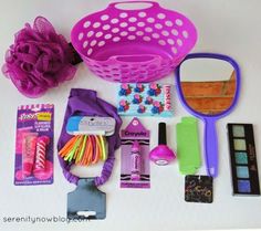 the contents of a purse laid out on a white table with pink and purple accessories