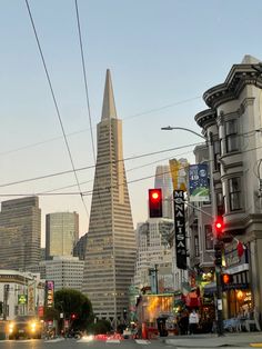 a city street filled with traffic next to tall buildings and power lines in the background