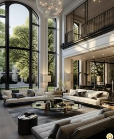 a large living room filled with lots of furniture next to tall windows and floor to ceiling windows