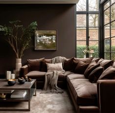 a living room filled with furniture and a large painting on the wall above it's windows