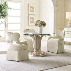 a glass table with chairs around it in a white living room filled with furniture and decor