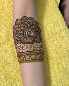 a woman's arm is decorated with hennap and peacocks on it