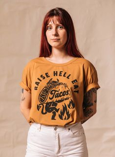 The Raise Hell Eat Tacos unisex adult t-shirt is made of high quality and comfy, vintage-inspired fabric (50% Polyester 25% Cotton 25% Rayon). The edgy graphic tee design features a taco slogan accompanied by a devil holding a taco. >> Find our size chart: pyknic.com/pages/sizing-chart >> We're on Instagram! Follow @Pyknic >> Sorry, we do not offer customization. >> Important: Products by PYKNIC [Pyknic USA LLC] are original designs and are protected by copyright laws. Yo Taco Shirt, Festival Shirts, Graphic Tee Design, Taco Tuesday, Shirts With Sayings, Tee Design, Branded T Shirts, Womens Tees, Graphic Tee