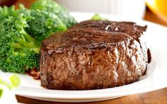 a steak and broccoli on a white plate