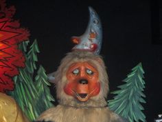 a close up of a person wearing a costume with trees and lights in the background