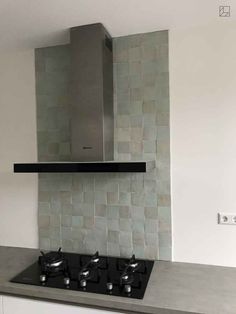 a stove top oven sitting inside of a kitchen next to a wall mounted exhaust fan