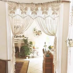 an open doorway with curtains and plants in it