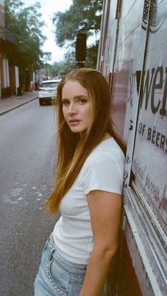 a woman leaning against the side of a food truck