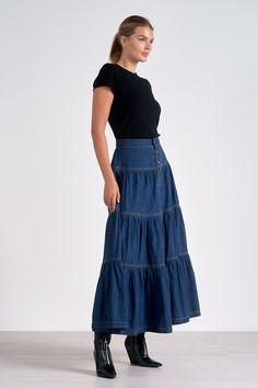 Step into bohemian elegance with the Daisy maxi skirt. Tiered layers of blue denim create a flowing silhouette, while contrast stitching adds visual interest. Button closure ensures both style and comfort in this versatile piece. Denim Dress Fall, Jumpsuit Coverup, Fall Bottoms, Skirt Tiered, Jumpsuit Summer, Cardigan Sweater Dress, Denim Skirts, Sweater Set, Fall Collections