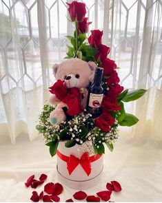 a teddy bear sitting in a vase with roses