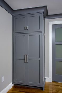 a tall gray cabinet sitting in the corner of a room