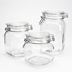 three clear glass jars with lids on white background