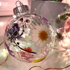 a glass ornament sitting on top of a table next to other ornaments and lights