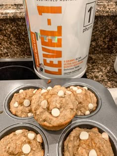 three muffins in a pan next to a can of energy drink on a counter