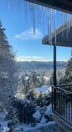 icicles hanging from the roof of a building in winter time with trees and snow covered ground