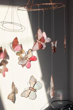 a mobile with butterflies hanging from it's sides in front of a light fixture