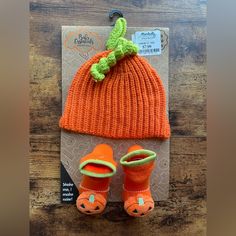 an orange knitted hat and booties are on the package for this baby's first halloween costume