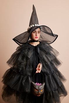 a woman wearing a black witch costume and holding a bucket