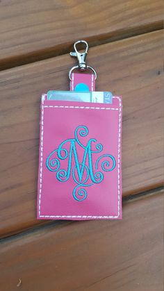 a pink card holder with a monogrammed initials on the front and back side