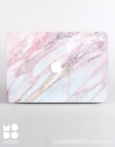 an apple logo on the back of a macbook pro with a marble pattern in white and pink