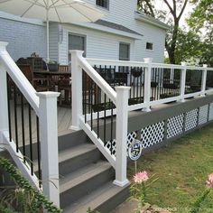 a deck with an umbrella over it next to a house