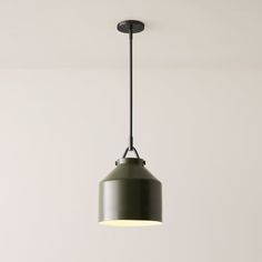 a green pendant light hanging from a ceiling in a room with white walls and flooring