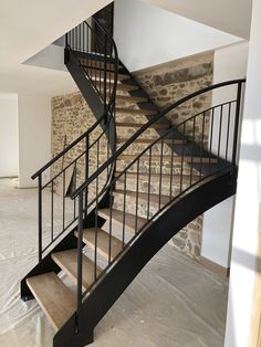 a spiral staircase in an empty room with white walls and flooring on the other side